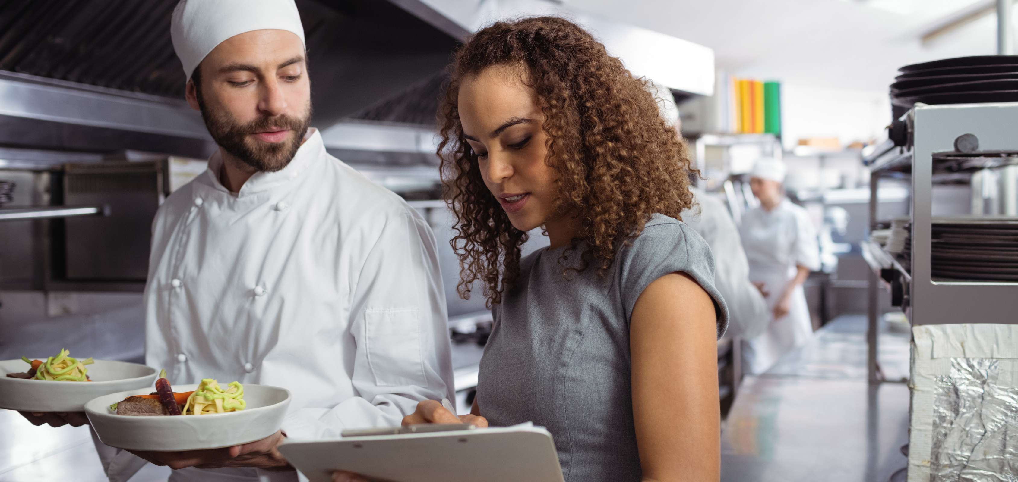 Business manager and chef talking in restaurant.